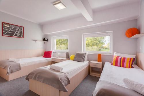 a room with two beds and two windows at Hostel Rakieta in Gdańsk