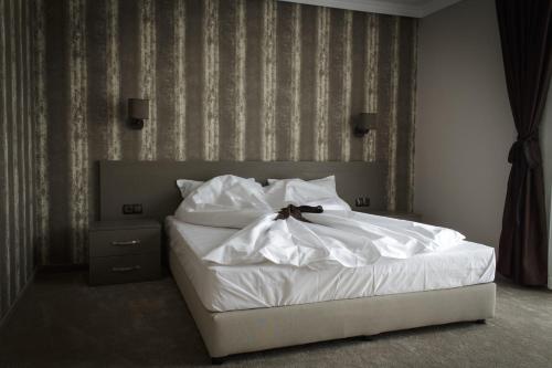 a bedroom with a white bed with a bow on it at Hotel Nove in Svishtov