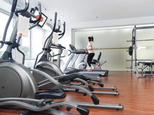 a woman running on a treadmill in a gym at HARRIS Suites fx Sudirman in Jakarta