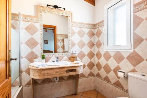 W łazience znajduje się umywalka i lustro. w obiekcie Villa Santi II by Villa Plus w mieście Cala'n Porter