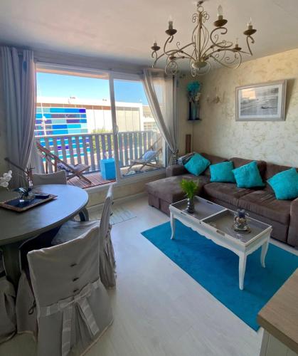 un salon avec un canapé et une table dans l'établissement St Valery en Caux, apt vue mer et falaise: le bleu de lô, à Saint-Valery-en-Caux