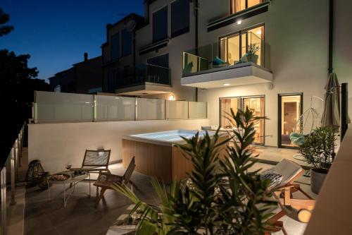 a house with a patio with chairs and a balcony at NEW! ReLux - ZF Hvar in Hvar