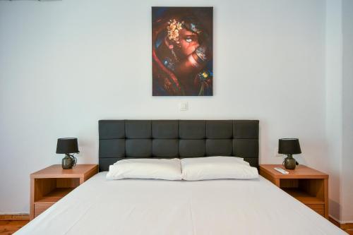 Un dormitorio con una cama con una pintura encima. en Thessaloniki Center Comfortable Apartment, en Tesalónica