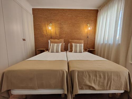 a bedroom with two beds with white sheets and a window at Corkoon - Duna Parque Resorts & Hotels in Vila Nova de Milfontes
