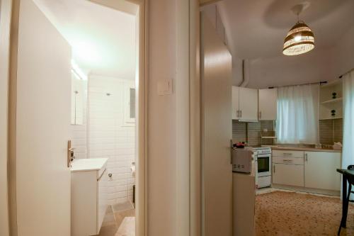 una cocina con armarios blancos y una lámpara. en Thessaloniki Center Comfortable Apartment, en Tesalónica
