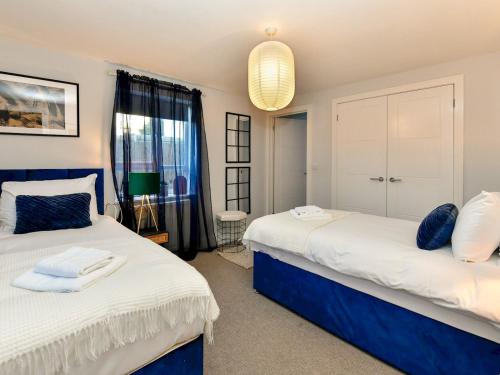 two beds in a room with blue and white at Pass the Keys Perfectly located stylish 2 bed home with Parking in Newport