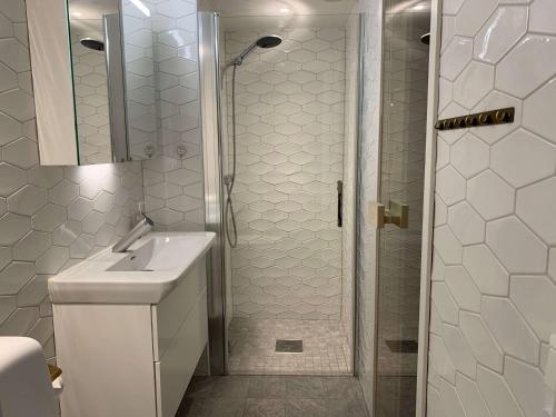 a white bathroom with a sink and a shower at Åre Travel - Center in Åre