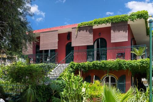 a red building with ivy on the side of it at Lord Ape Suites Club in Benitses
