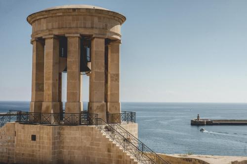 um edifício com escadas junto ao oceano em The Coleridge Boutique Hotel In Valletta em Valeta