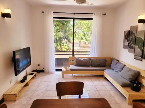 Una sala de estar con un sofá y un televisor. en Lovely Apartment in Relaxing Homey Environment, en Pannipitiya