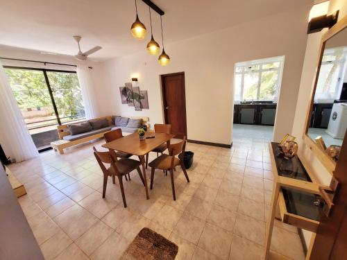 Una sala de estar con una mesa y sillas de madera. en Lovely Apartment in Relaxing Homey Environment, en Pannipitiya