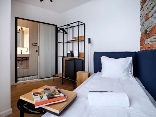 a bedroom with a bed and a table with a book at LJ5 - Old Town Rooms with Exclusive shared Roof Terrace in Tallinn