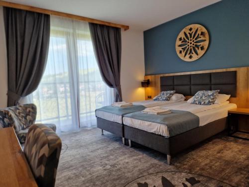 a hotel room with a bed and a large window at Malinowy Potok in Białka Tatrzanska