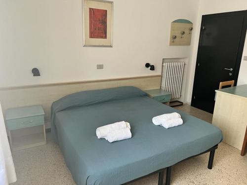 a bedroom with a bed with two towels on it at Ubika Hotel in Porto San Giorgio