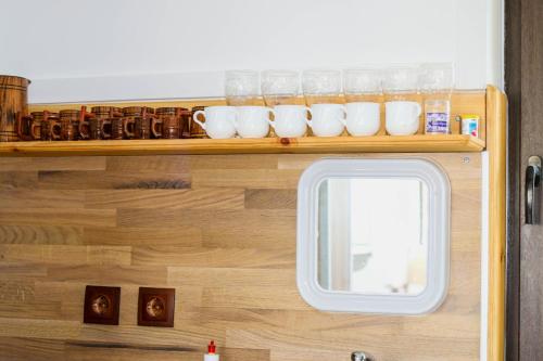 a row of cups on a shelf next to a window at Къща за гости,,Вила Росица,, in Shabla