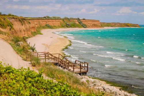 una escalera de madera que conduce a una playa junto al océano en Къща за гости,,Вила Росица,,, en Shabla