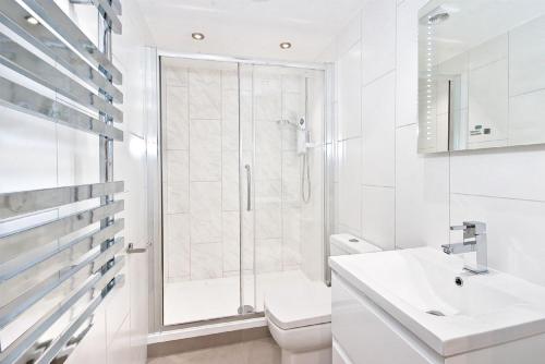 a bathroom with a shower and a toilet and a sink at Eldon Chambers Flat 1 by City Living London in London