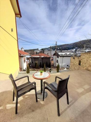 a patio with two chairs and a table in a yard at Villa La Munte in Kruševo