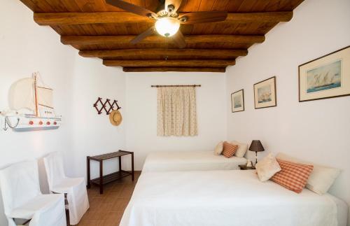 two beds in a room with a ceiling at Villa Abella Paraga Mykonos, Traditional with amazing sea view, up to 6 people in Paradise Beach