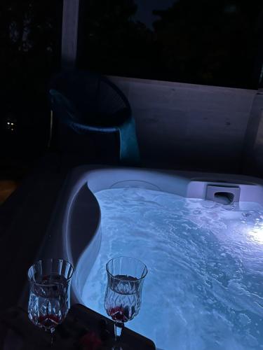 a jacuzzi tub with two wine glasses in it at Romantic apartments in Šibenik