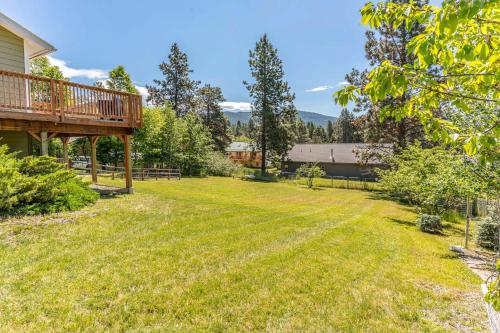 a large yard with a deck and grass at Cozy Escape in Bigfork