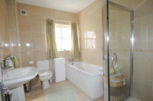 a bathroom with a tub and a toilet and a sink at slieve rushen in Derrylin