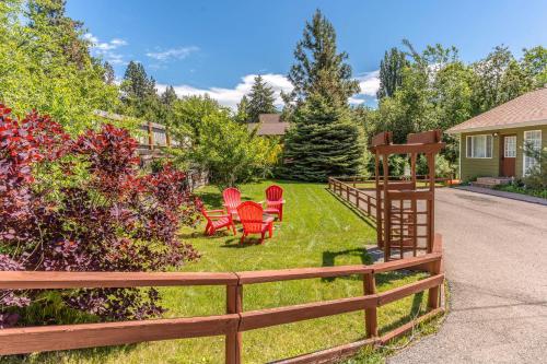 a yard with red chairs and a fence at Cozy Escape in Bigfork