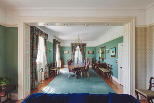 a dining room with green walls and a table and chairs at Equestrian Manor in Upton upon Severn