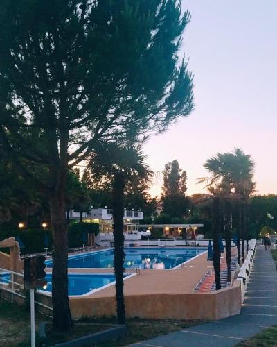 a swimming pool with trees next to a resort at Villaggio Costa d'Argento in San Vito Chietino