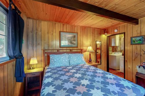 um quarto com uma cama num quarto com paredes de madeira em Mellow Deer em Groveland