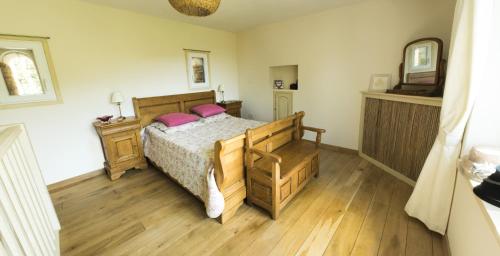 ein Schlafzimmer mit einem Bett mit rosa Kissen darauf in der Unterkunft Chapel Cottage in La Bachellerie