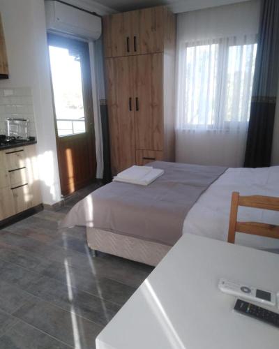 a bedroom with two beds and a table and a window at Nur Konak daire 3 in Çanakkale