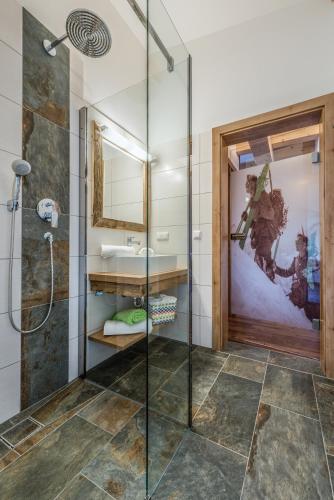 a bathroom with a glass shower and a sink at Chalets AurAlpin in Kleinarl