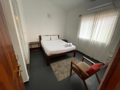a bedroom with a bed and a chair and a window at Cheerful 2-Bedroom Villa with Private Plunge Pool, Candolim, Goa in Marmagao