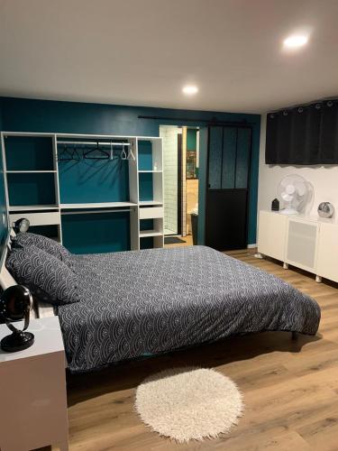 une chambre avec un grand lit et un mur bleu dans l'établissement la petite Poyannaise, à Poyanne