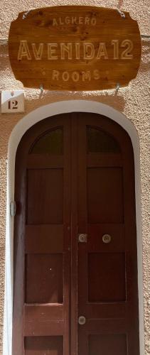 a door to a building with a sign above it at Avenida 12 in Alghero