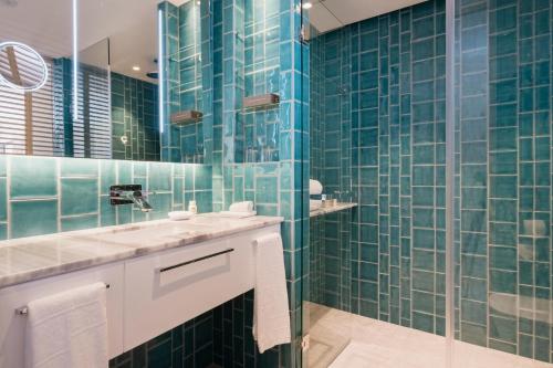 a bathroom with green tiled walls and a sink at El Vicenç de la Mar - Adults Only - Over 12 in Pollença