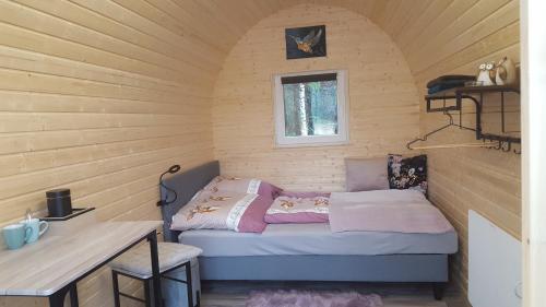 a small room with a bed in a wooden wall at Glamping Pod in Nordholz