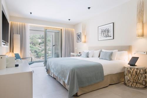 a bedroom with a large bed and a large window at El Vicenç de la Mar - Adults Only - Over 12 in Pollença