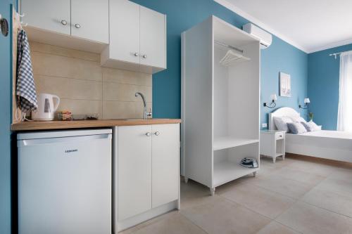 cocina con armarios blancos y baño con cama en Evi Boutique Rooms, en Galatás