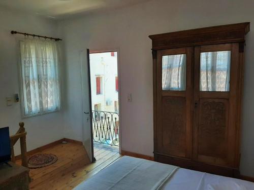 a bedroom with a wooden door and a balcony at The Garden in Chios