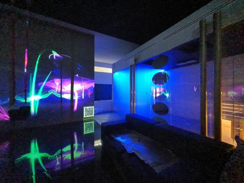a room with blue and green lights on the wall at X Hotel in Saviano