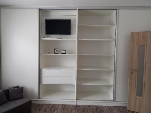 a white book shelf with a tv on it at Apartmán U Jakuba in Dvůr Králové nad Labem