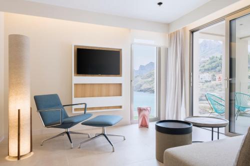 a living room with a couch and chairs and a tv at El Vicenç de la Mar - Adults Only - Over 12 in Pollença