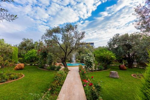 a garden with a pathway and a swimming pool at Gurel Garden House in Kucukkuyu