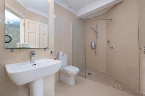 a bathroom with a sink and a toilet and a shower at The Old Schoolhouse of Warren Lodge Boutique Cottages in Dromod