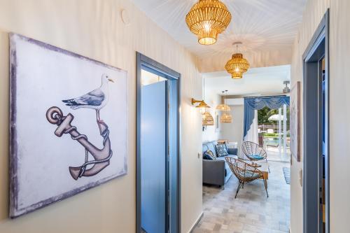 a hallway with a painting of a bird sitting on a limb at AGNONTAS LUXURY VILLAS in Agnontas