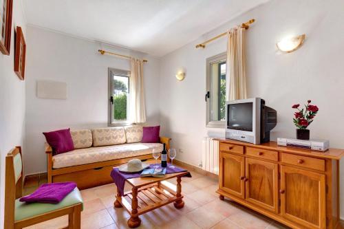 a living room with a couch and a tv at Villa Caballero by Villa Plus in Punta Prima