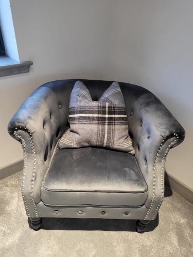a leather couch with a pillow on top of it at Machrie View in Port Ellen