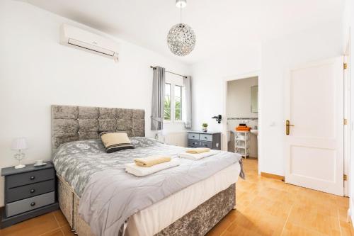 a bedroom with a large bed with two towels on it at Villa Sidanya by Villa Plus in Cala en Porter